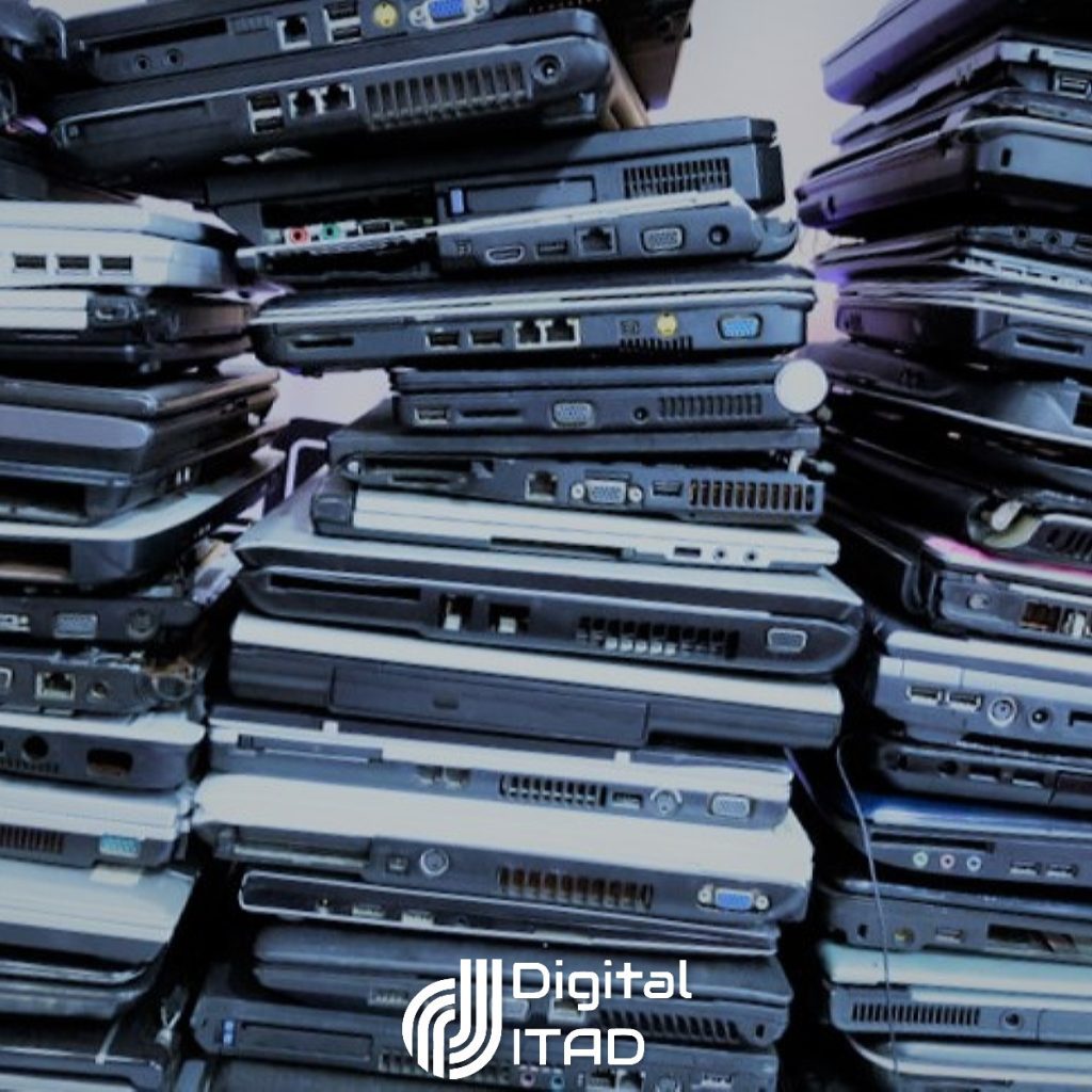 A large stack of used or end-of-life laptops